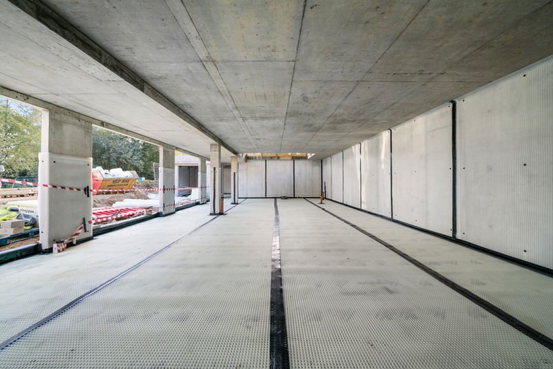 Interior construction showing concrete ceiling and floor preparation.