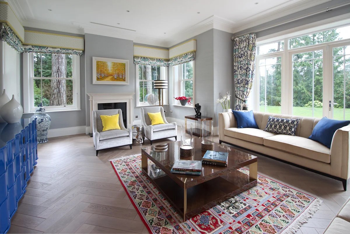 Living room with herringbone wood floor and period features.