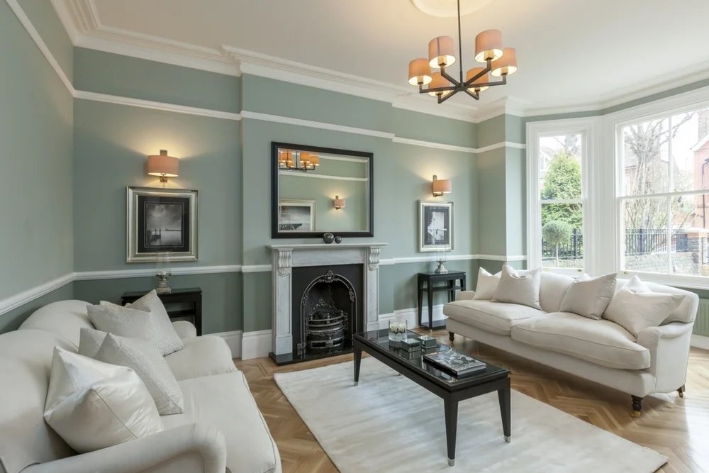Living room with light wood flooring and period features.