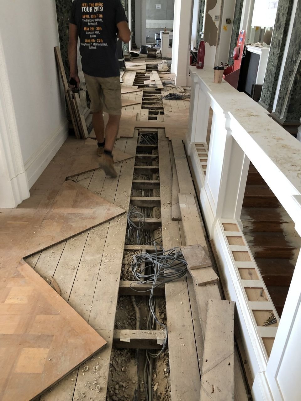 Floor restoration in progress, showing subfloor and parquet flooring.