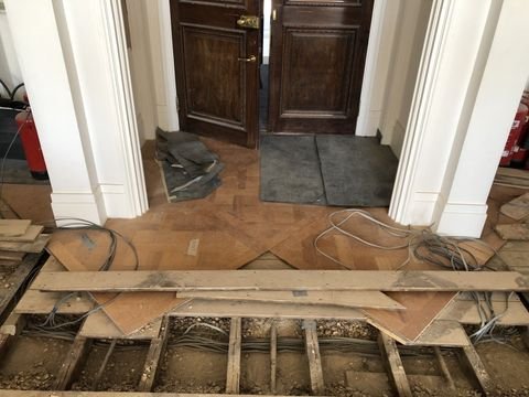 Close-up of floor restoration, showing parquet flooring and subfloor work.
