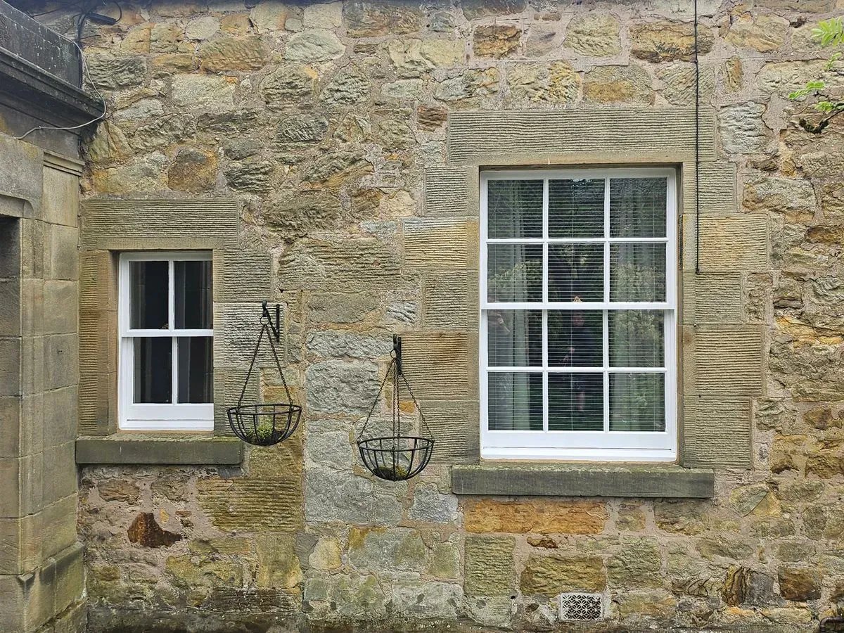 Sash window with a view of a garden, showing the window's functionality and aesthetic appeal.