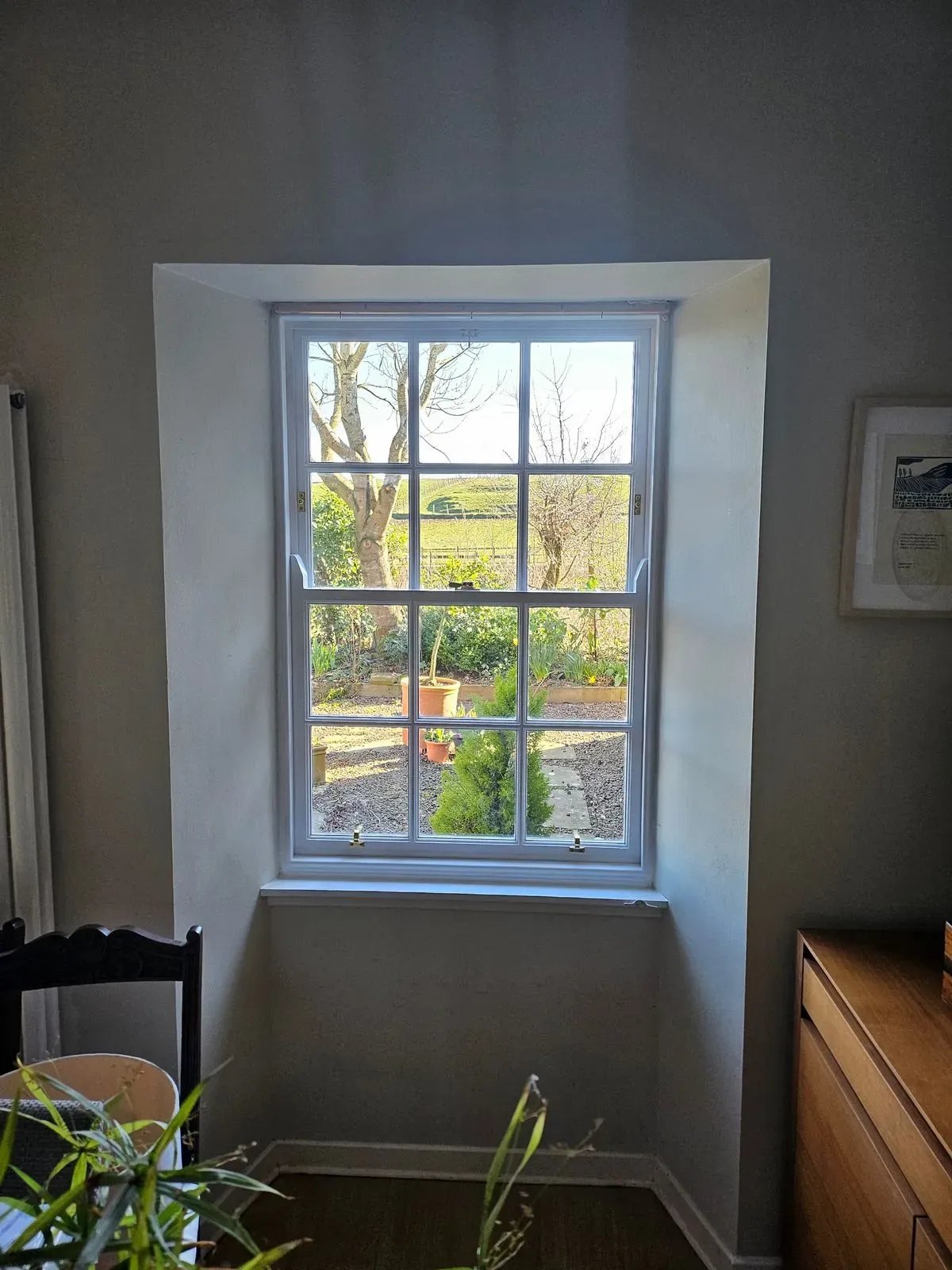 Exterior shot of two sash windows in a stone wall, highlighting the window styles and building facade.