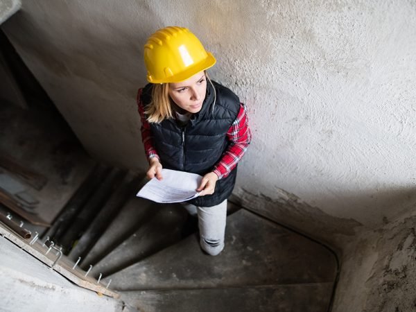 Construction worker inspecting a property, suggesting pre-restoration assessment.