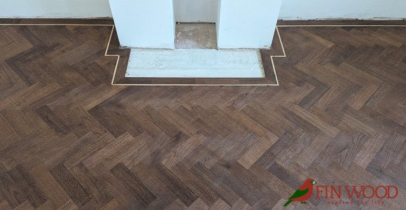 Dark wood flooring in a room with a fireplace.