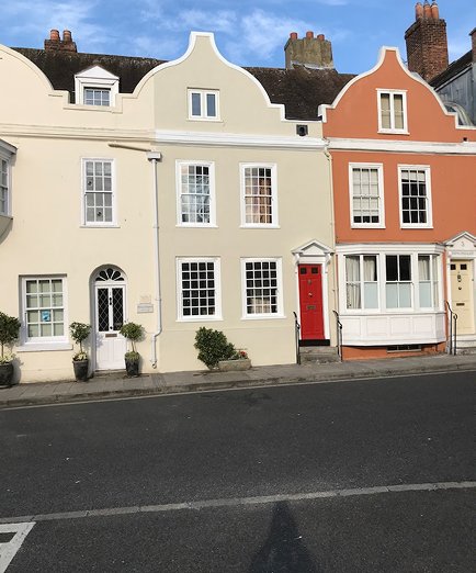 Row of period homes with restored sash windows, showcasing variety and style.
