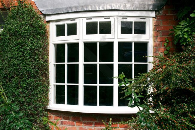 Bay window with white frames in a brick building.