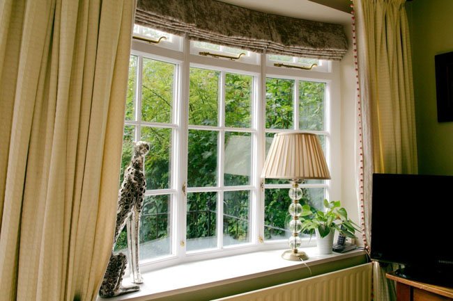 Interior view of a bay window with curtains and decor.