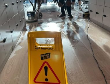 Floor polishing in progress with warning sign.
