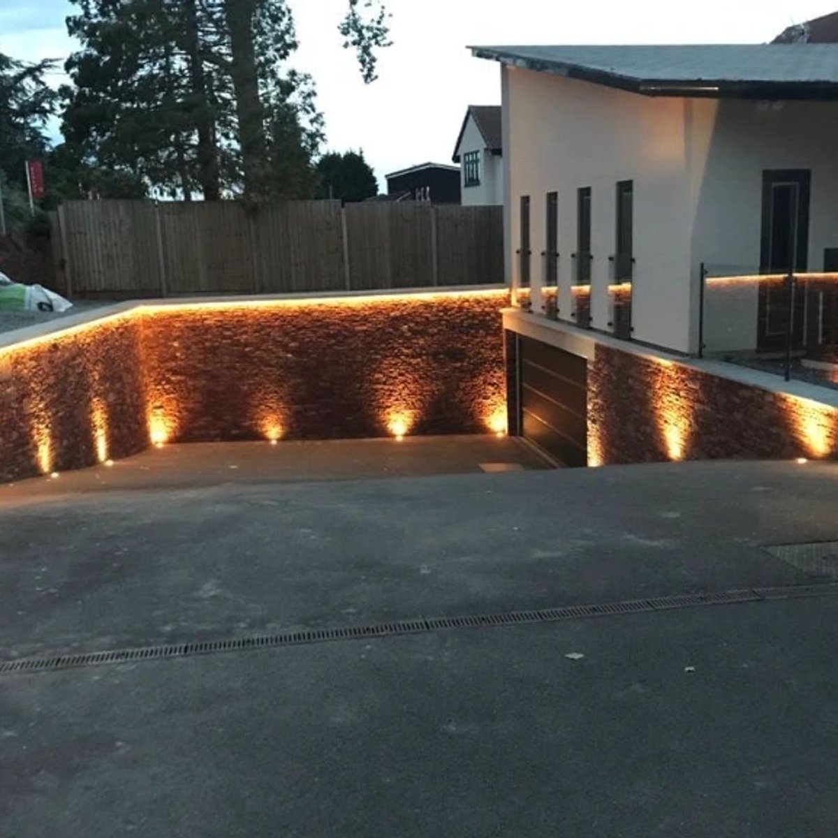 Stone retaining wall with lighting, showcasing masonry skills.