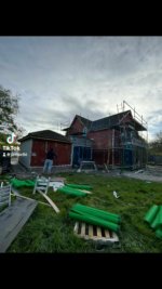 House under construction with scaffolding, suggesting building restoration or new build with potential for lime plastering.