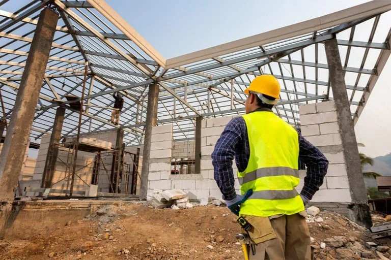 Construction worker overseeing a building project, showing construction in progress.