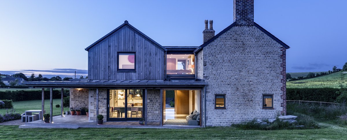 Exterior shot of a restored brick and wood home with modern additions.