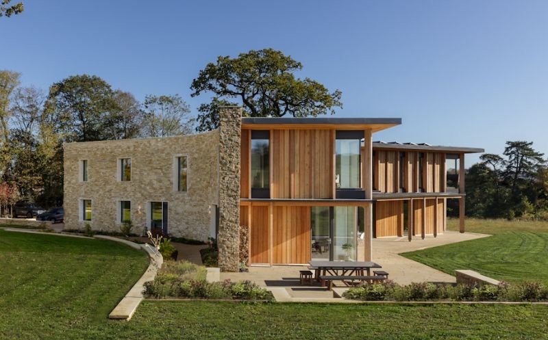 Exterior shot of a restored stone and wood home with modern additions.