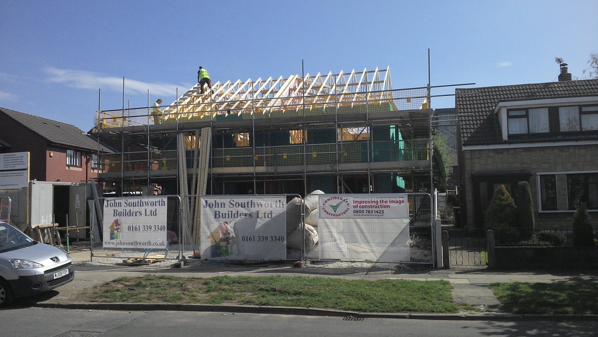 Construction site with timber frame roof being built. Shows the construction process.
