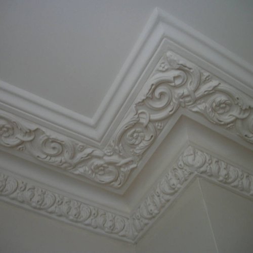Close-up of ornate plaster cornice work in a corner.