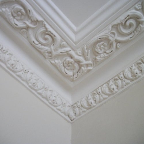 Close-up of ornate plaster cornice work in a corner.