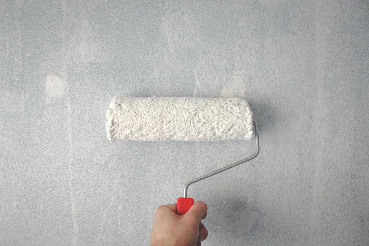 Image of a paint roller applying paint to a wall, demonstrating painting services.