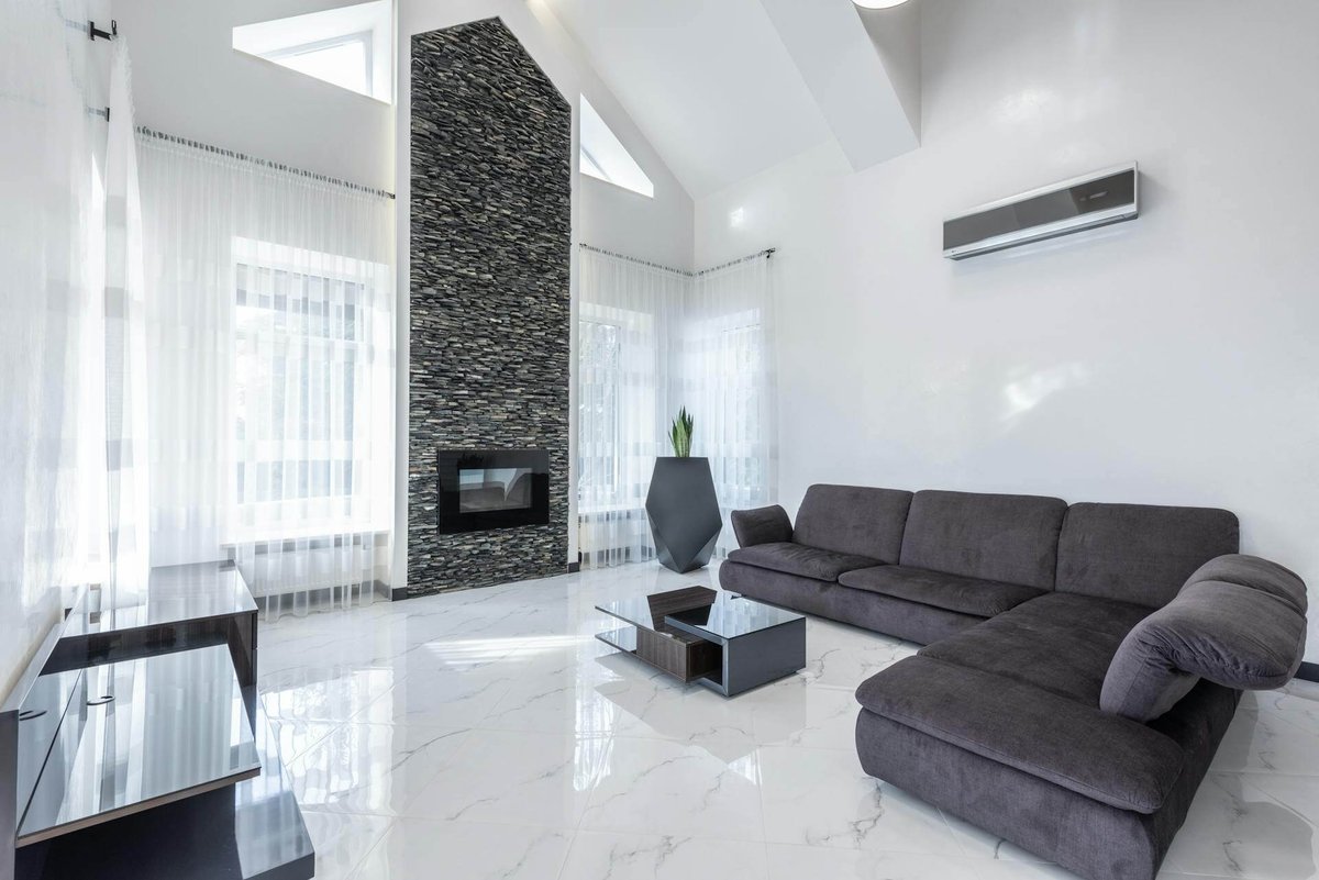 Modern living room with a stone fireplace and air conditioning unit, potentially showcasing renovation and installation services.