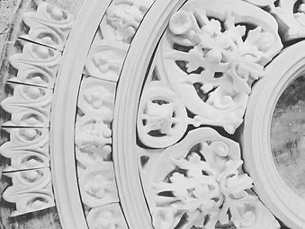 Close-up of a decorative ceiling medallion, showcasing intricate details in black and white.