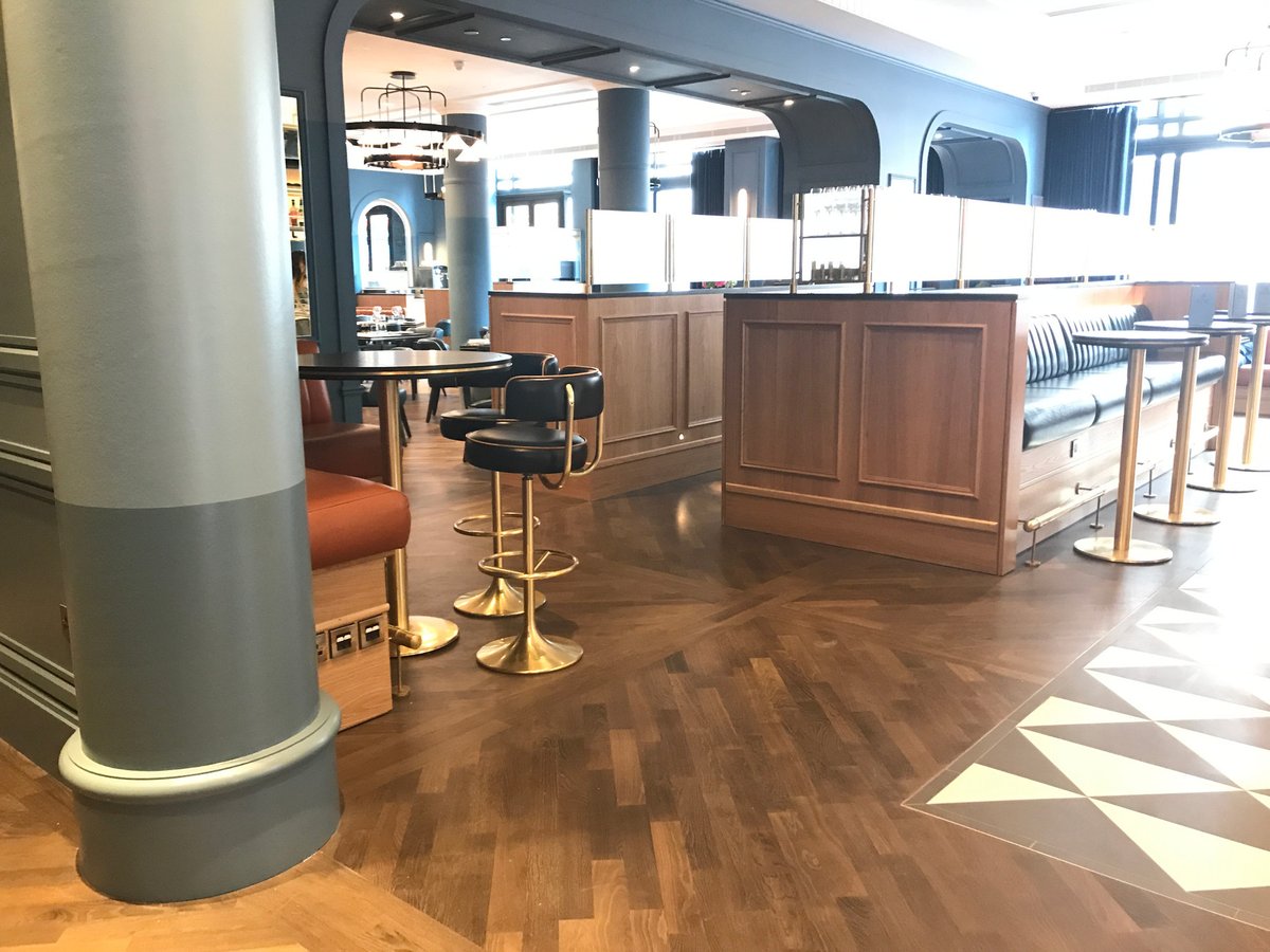 Wide shot of a restaurant interior featuring a herringbone parquet floor, highlighting the company's ability to handle large-scale projects.