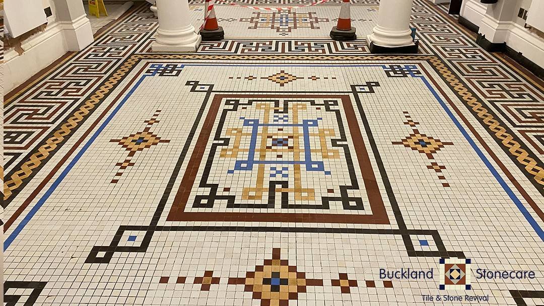 Intricate mosaic tile floor restoration.