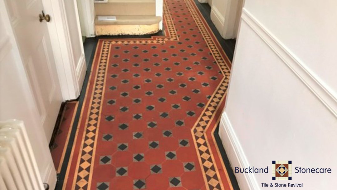 Restored hallway with red and black patterned tiles.