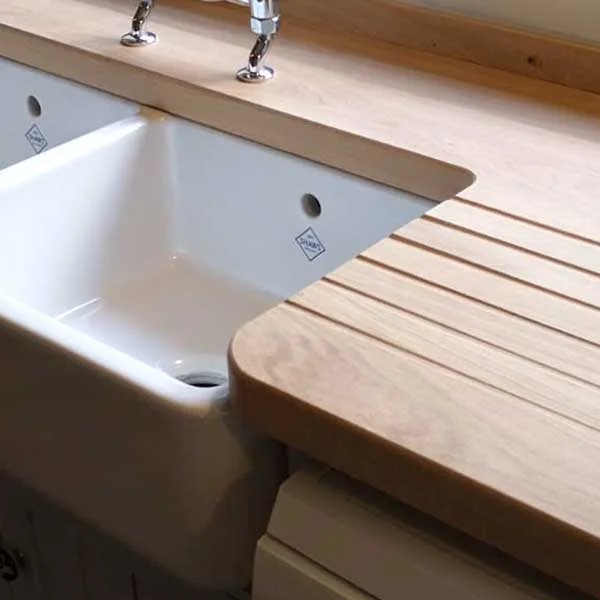 Close-up of a wooden countertop with a Belfast sink and integrated draining board.