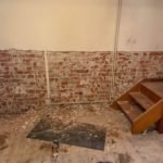 Interior wall being restored, showing brickwork