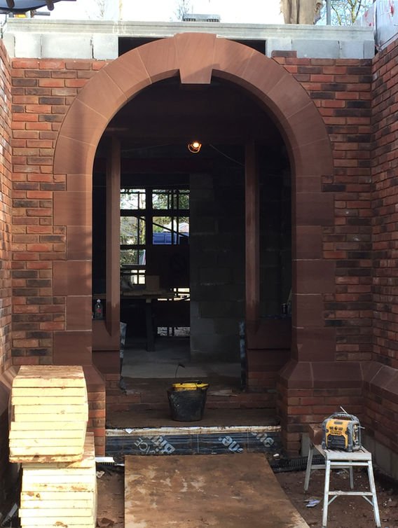 Stone archway under construction, clearly demonstrating masonry work in progress.
