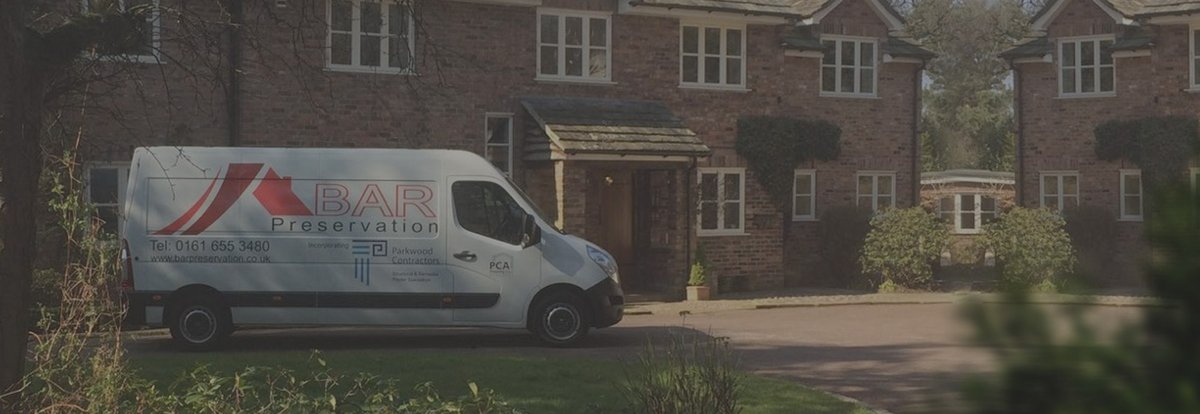 Van with the company logo parked in front of a building.