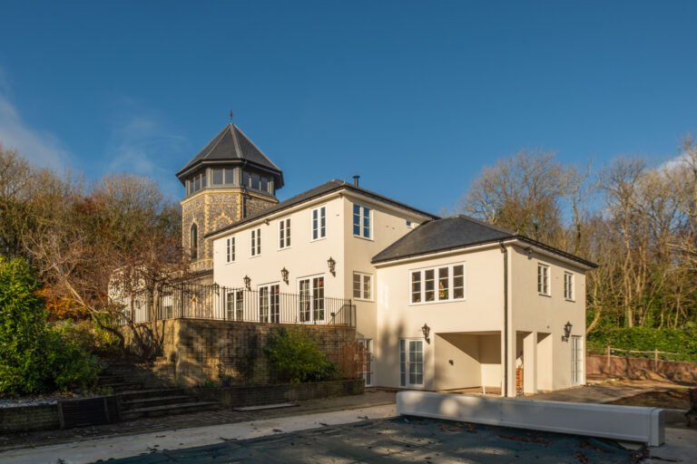 Exterior of a large house with visible plastering, potentially showcasing their work.