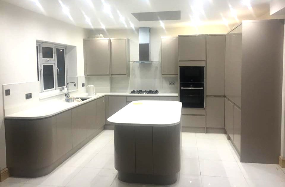 Modern kitchen renovation with grey cabinets and a central island.