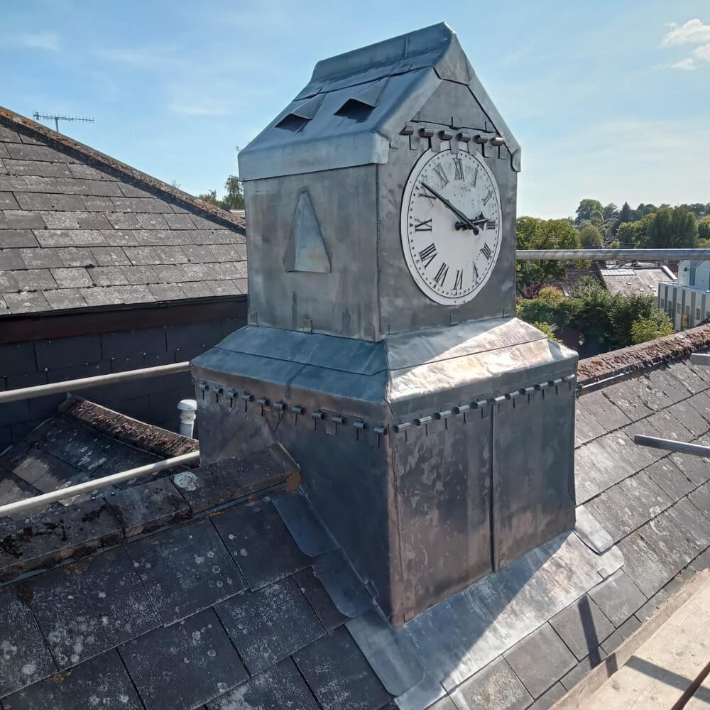Clock tower on a slate roof.