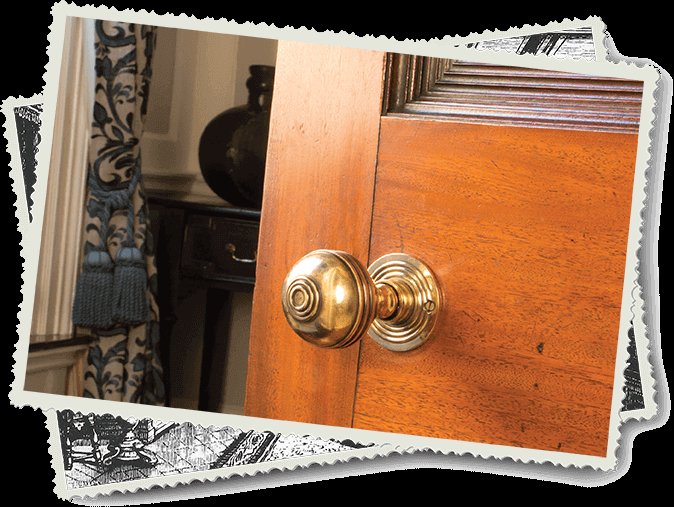 Close-up of a restored wooden door with a brass doorknob.