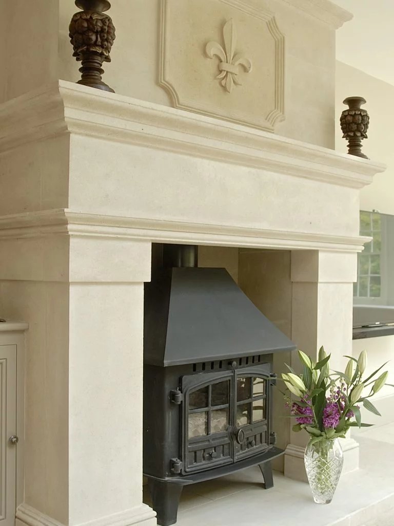 Fireplace with stone surround and wood-burning stove, showcasing their fireplace services.
