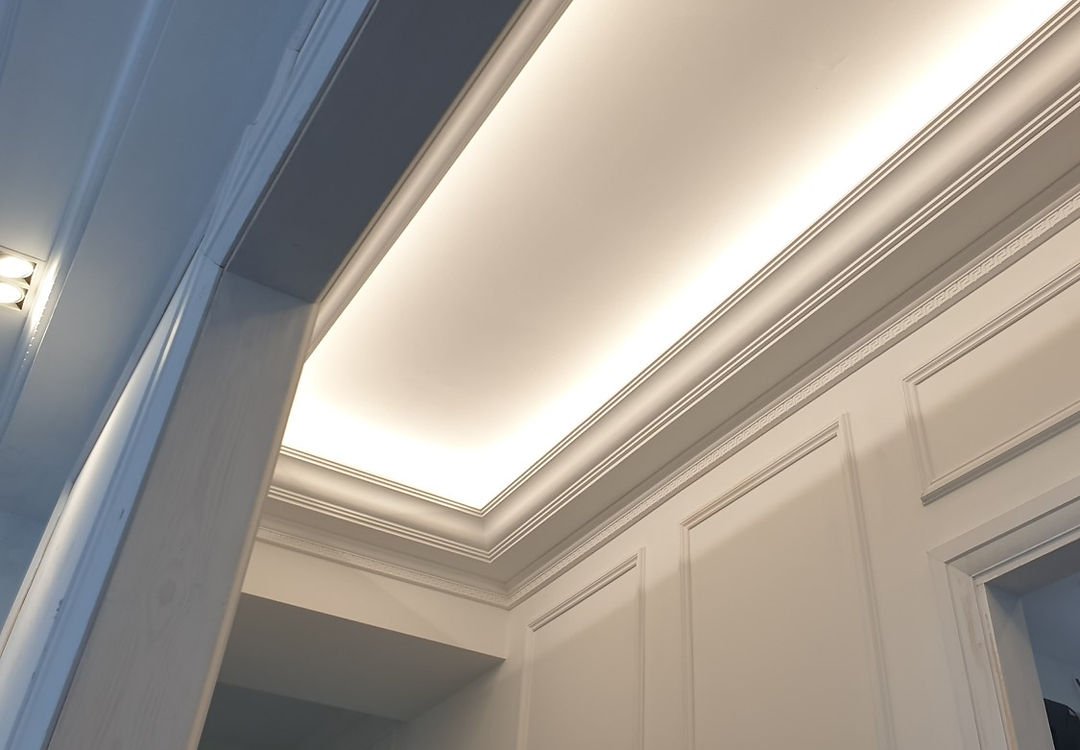 Detailed coving and ceiling work, showcasing lighting and paneling.