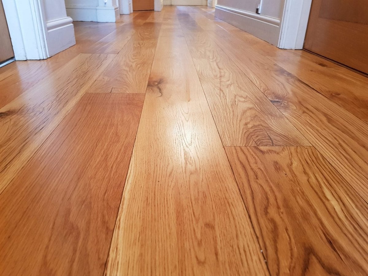 Close-up of a hallway with newly installed or restored wood flooring.