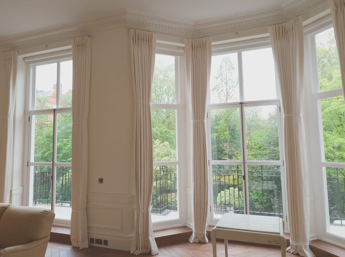 Interior shot of multiple newly installed windows with curtains.