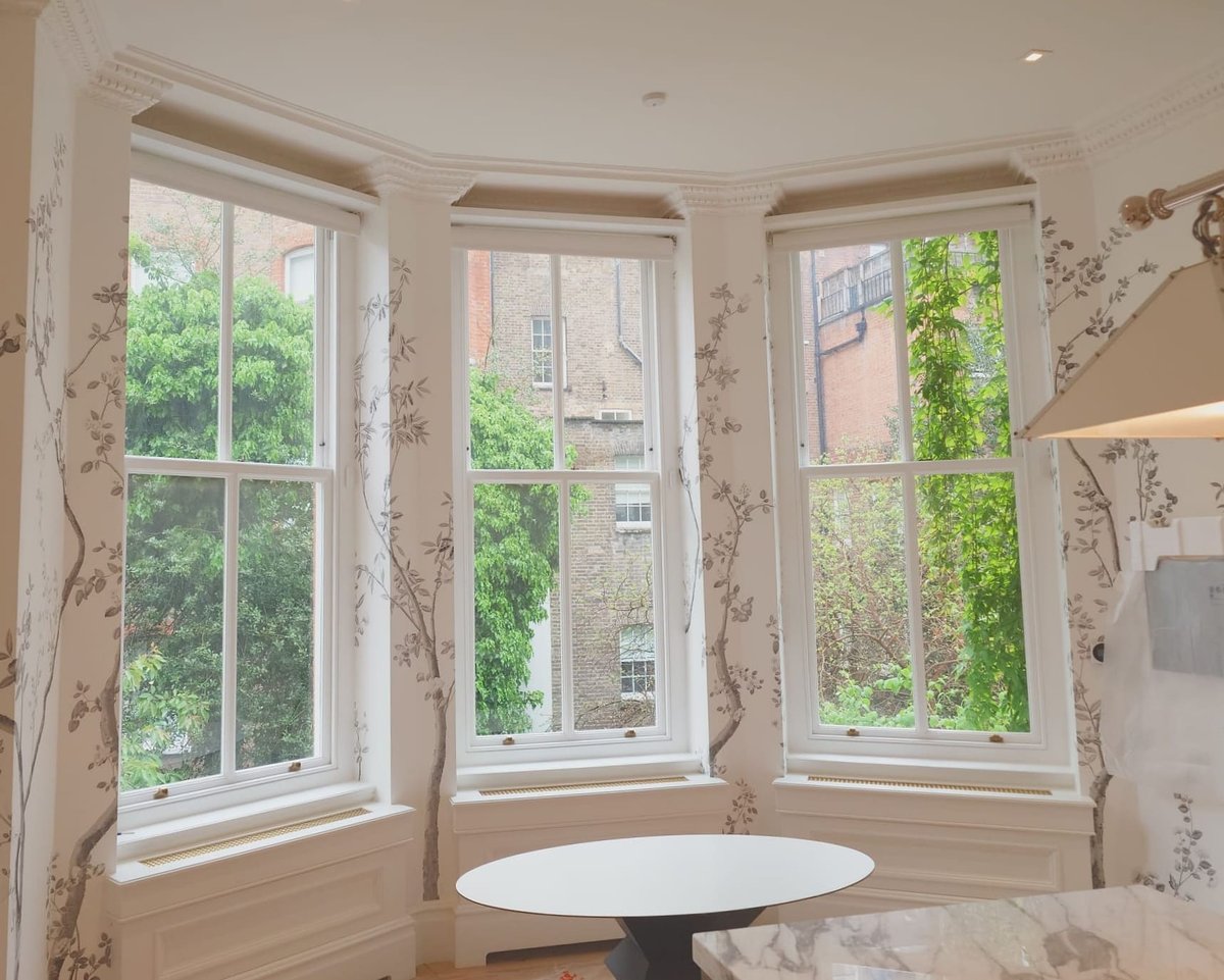 Interior shot of bay windows with decorative wallpaper.