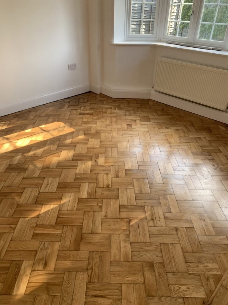 Finished wooden floor in a room with windows