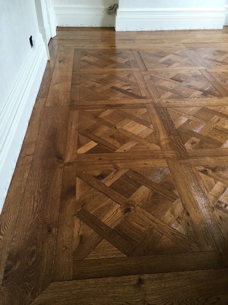 Intricate wood floor pattern installation.