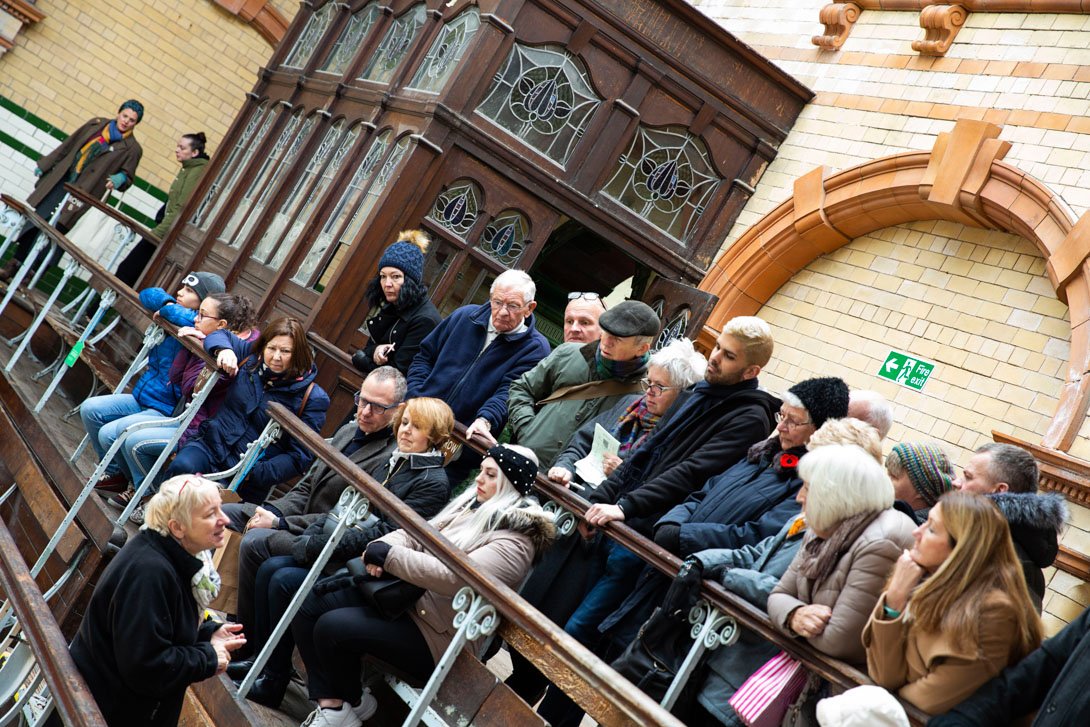 Group of people on a tour of the building, showing original features.