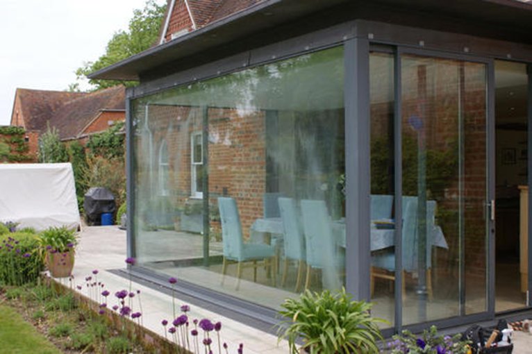 Modern glass extension with sliding doors on a period home.