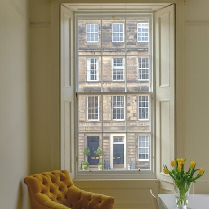 Close-up of a restored sash window on a stone building.
