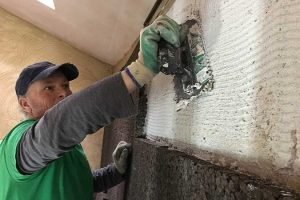Plasterer applying plaster to a wall.