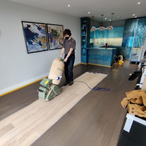Floor sanding in progress in a modern room.