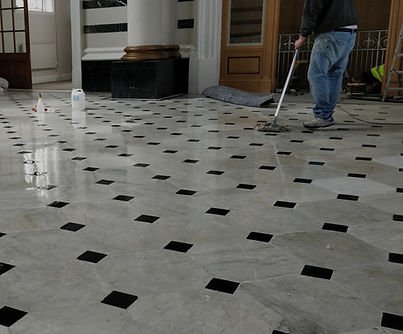 Marble tile floor being polished, showing the restoration process.