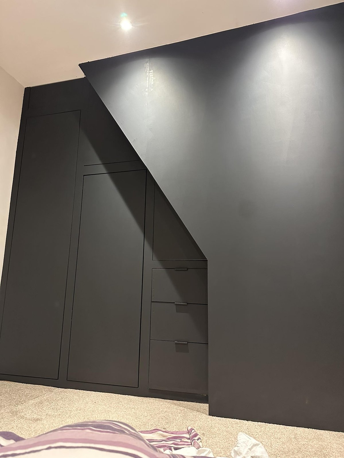 Bespoke under-stairs storage unit with drawers and doors.