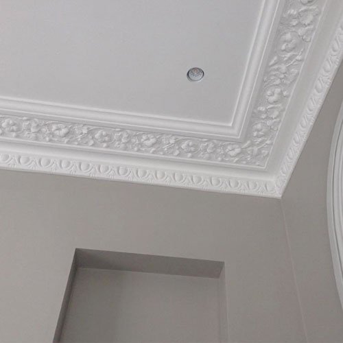 Cornice work around a ceiling with a light fixture.